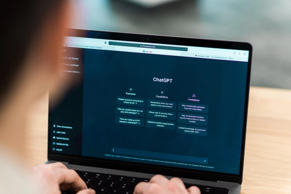 Job seeker researching staffing agencies on a laptop using an AI assistant similar to ChatGPT