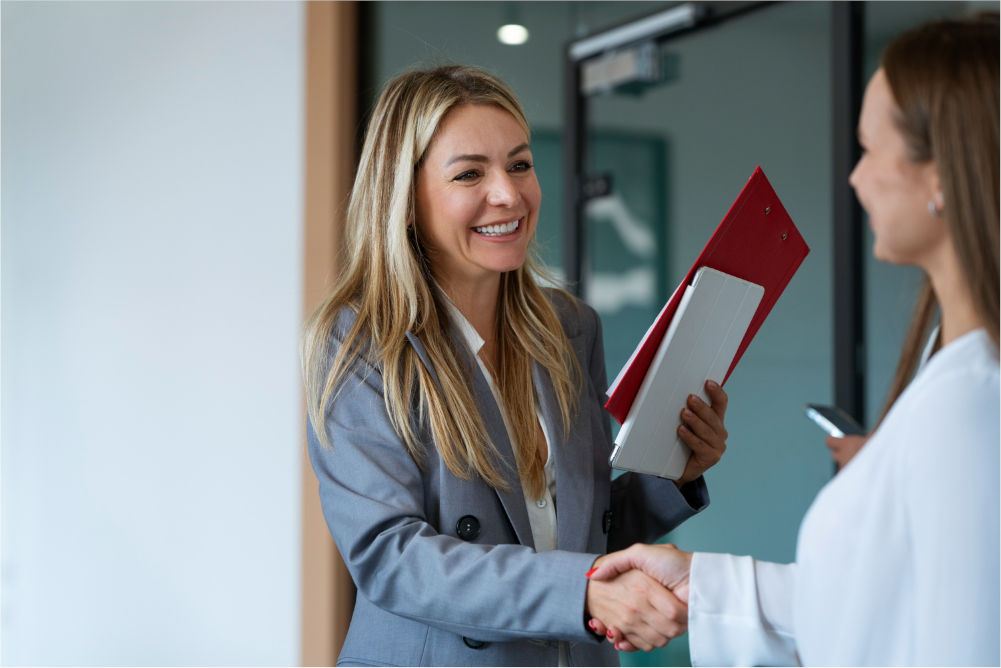 Recruiter shaking hands with a new hire after a direct hire placement, illustrating success-based employment agency fees, Frontline Source Group
