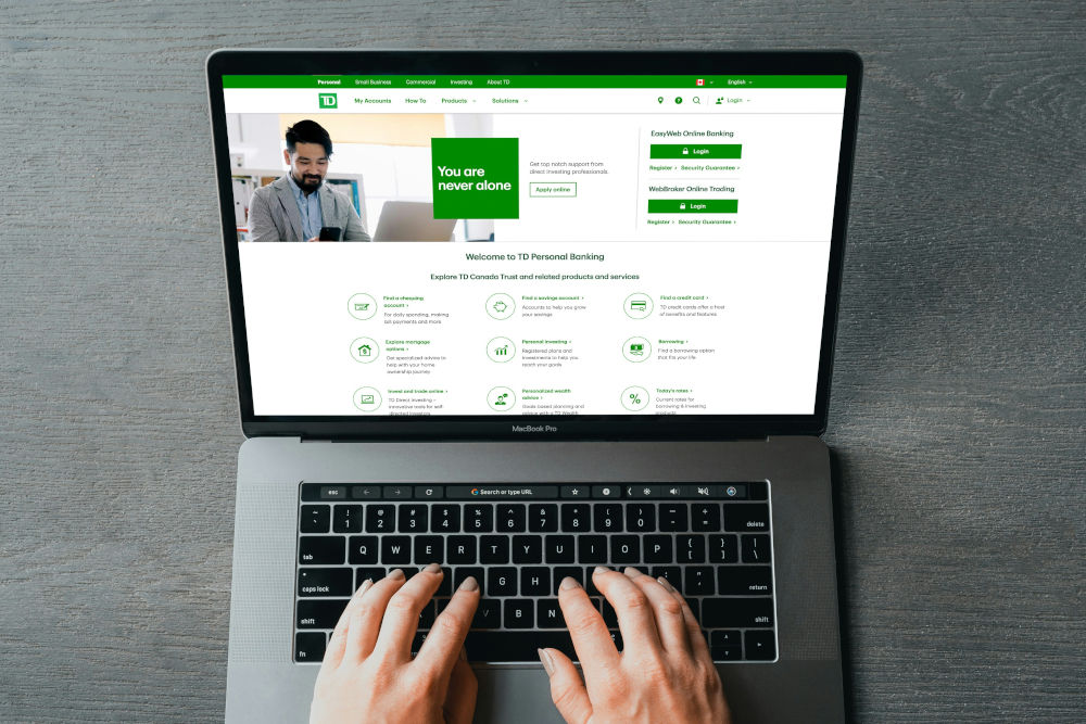 Hands typing on a laptop that displays a clean green and white staffing agency website layout with clear navigation and calls to action