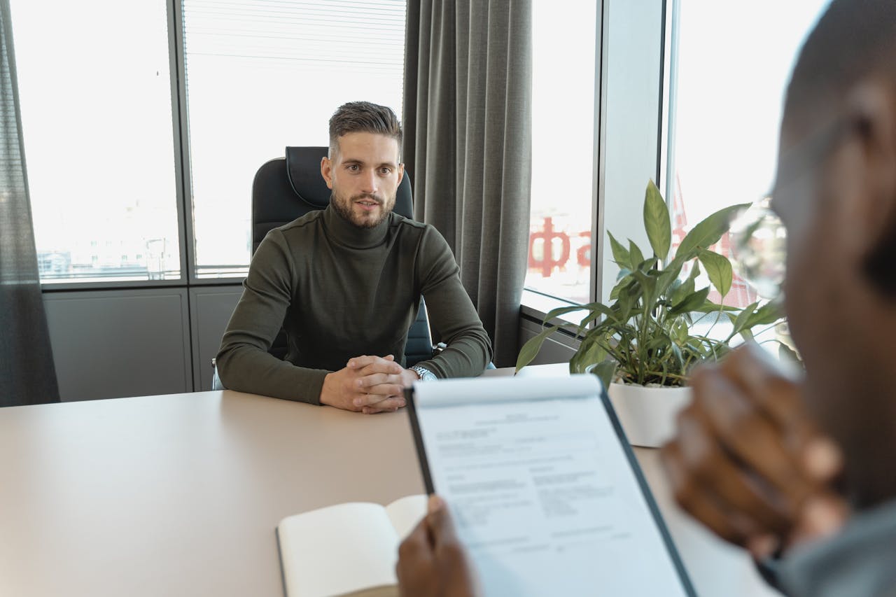 Clerical candidate in a professional interview setting with the hiring manager reviewing the resume